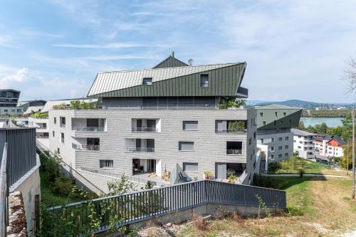 a large white building with a green roof at La Providence in Annecy