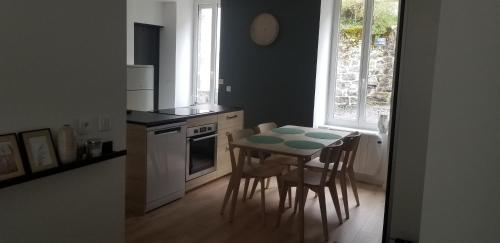 une cuisine avec une table et des chaises et une cuisine avec une fenêtre dans l'établissement Résidence Les Sources centre-ville F3, à Le Mont-Dore