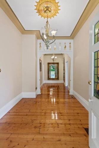 an empty hallway of a home with a chandelier at Beautiful Federation Residence for 16 Guests great for wedding functions in Bunyip
