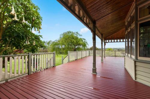 a porch with a wooden deck with a fence at Beautiful Federation Residence for 16 Guests great for wedding functions in Bunyip