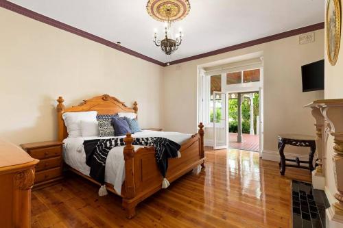 a bedroom with a bed and a chandelier at Beautiful Federation Residence for 16 Guests great for wedding functions in Bunyip