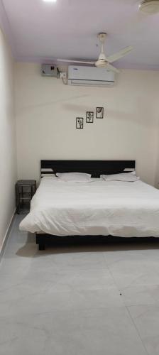 a white bed in a white bedroom with a ceiling at Dhanavade farms in Neral