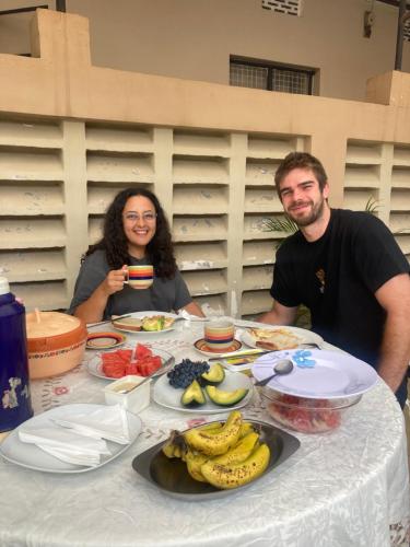 a man and woman sitting at a table with food at WEST ORANGE LODGE in Moshi