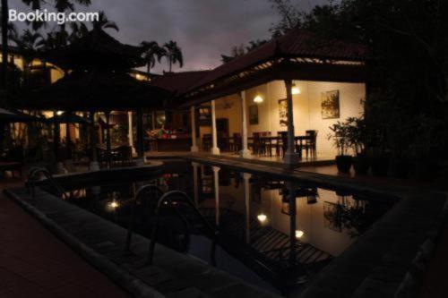 a house with a swimming pool at night at Sarinande Hotel in Seminyak