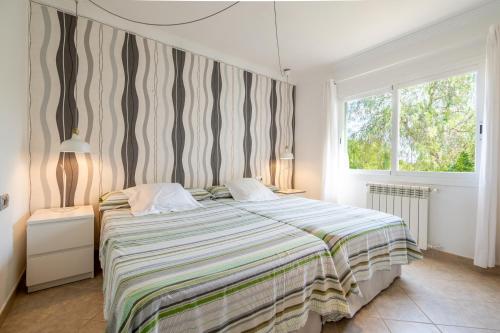 a bedroom with a large bed and a window at Villa Fina in Colònia De Sant Jordi