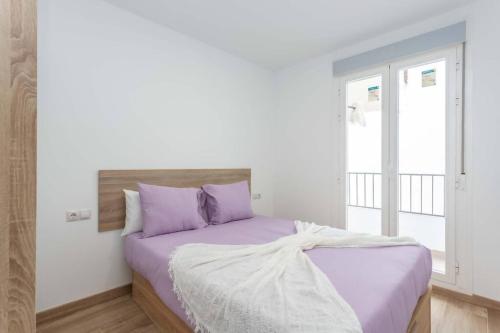 a bedroom with a bed with purple sheets at Apartamento elegante villa verde 1B in Villaverde
