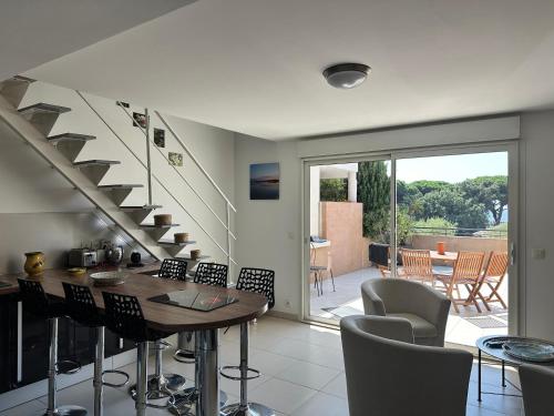 un salon avec une table et un escalier dans l'établissement Évasion en Méditerranée, à La Garonnette-Plage