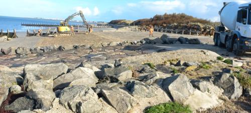 un camion de construction garé sur une plage de rochers dans l'établissement Le cocon du port Appartentre port et plages, à LʼHerbaudière