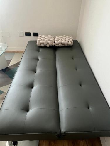 a large black couch in a room at Monolocale Ovidio in Milan