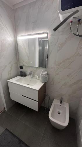 a white bathroom with a sink and a toilet at Monolocale Ovidio in Milan