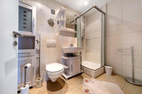 Un baño con inodoro, lavabo y ducha. en Apartment Ankerplatz, en Bremerhaven