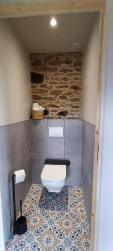 La salle de bains est pourvue de toilettes et d'un mur en pierre. dans l'établissement La chouette, à La Malonie