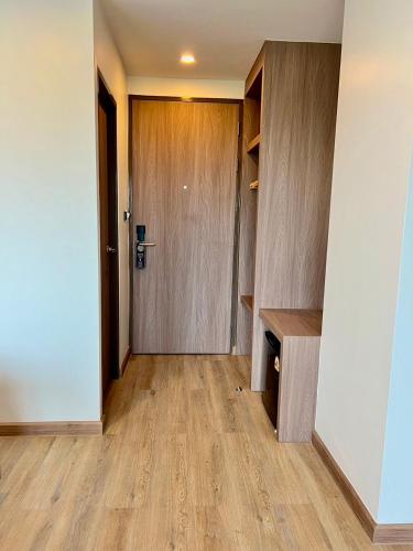 a hallway with a door and a wooden floor at เวลโกรว์ โฮเทล - Wellgrow Hotel in Ban Bang Kha