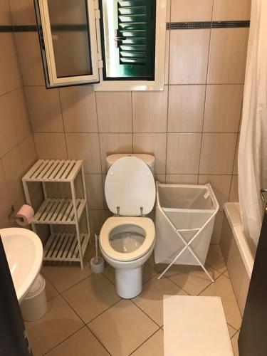 une salle de bain avec toilettes et lavabo dans l'établissement Lozarifamily, à Belgodère
