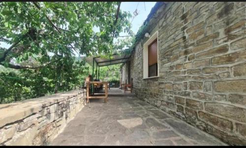 a stone house with a stone wall and a patio at Gest House Felau in Përmet