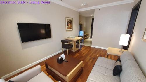 a living room with a couch and a flat screen tv at Lavender Hotel Al Nahda Dubai in Dubai