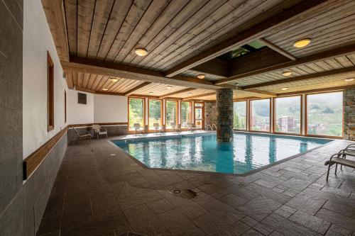 - une grande piscine dans un bâtiment doté de fenêtres dans l'établissement Résidence Aspen, à La Plagne Tarentaise