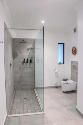 a glass shower in a bathroom with a toilet at Cresta Mowana Safari Resort & Spa in Kasane