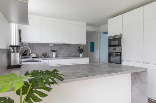 Private villa in central Östersund في أوسترسوند: مطبخ بخزائن بيضاء وطاولة عمل