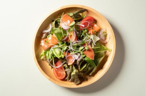 a salad in a wooden bowl on a table at ホテル ブルジュア 久留米 Hotel Bvljua -レジャーホテル- in Kurume