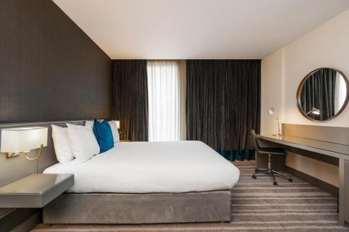 a hotel room with a bed and a desk at Crowne Plaza Newcastle - Stephenson Quarter by IHG in Newcastle upon Tyne
