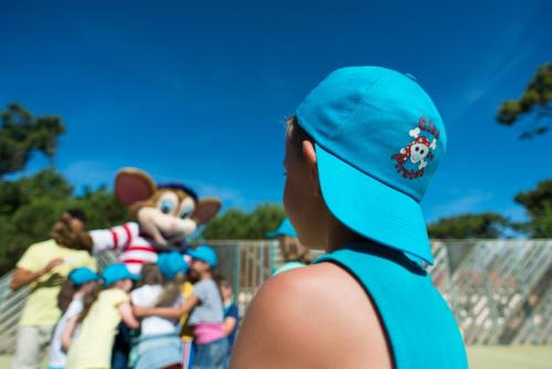 a woman wearing a blue hat and a group of children at Camping Officiel Siblu Le Bois Dormant in Saint-Jean-de-Monts