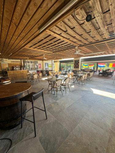 un restaurant avec des tables et des chaises et un bar dans l'établissement Camping Le Mas Sud Ardèche, à Saint-Just
