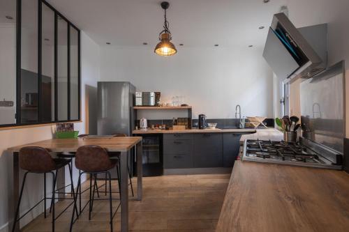 une cuisine avec une table et une cuisinière four supérieur dans l'établissement Appartement spacieux au cœur d'Angers étage 1 - 6 personnes, à Angers