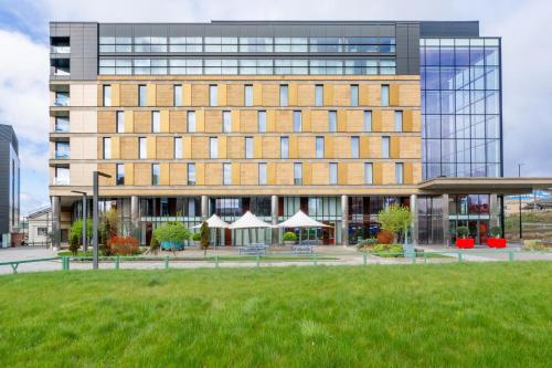 a large building with a grass field in front of it at Crowne Plaza Newcastle - Stephenson Quarter by IHG in Newcastle upon Tyne