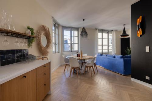 Il comprend une cuisine et un salon avec une table et un canapé bleu. dans l'établissement Appartement spacieux au cœur d'Angers étage 2 - 6 personnes, à Angers