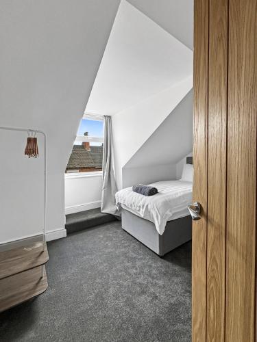 une chambre avec un lit et une fenêtre dans l'établissement Amaya One -3 bedroom townhouse - with garden - close to town centre - sleeps 7, à Grantham