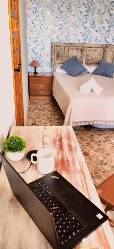 a laptop on a table in a room with two beds at Casa Rural Teralba 2 in La Calzada de Oropesa