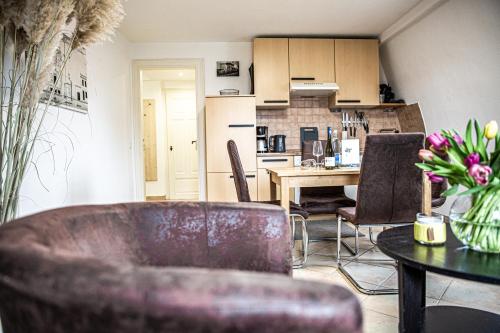 a living room with a table and chairs and a kitchen at Haus Felix Radebeul Weinbergblick in Radebeul
