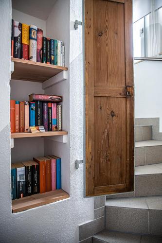 a book shelf with books on it next to a door at Haus Felix Radebeul Weinbergblick in Radebeul