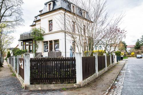 a white house with a fence in front of it at Haus Felix Radebeul Weinbergblick in Radebeul