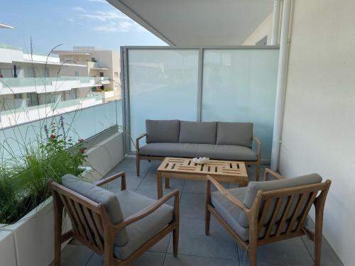 - un balcon avec un canapé, deux chaises et une table dans l'établissement Très beau F2 neuf 50 M2 , grande terrasse 30 M2, très bien situé, à Narbonne