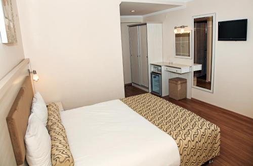 a hotel room with a bed and a sink at Grand Zeybek Hotel in Izmir