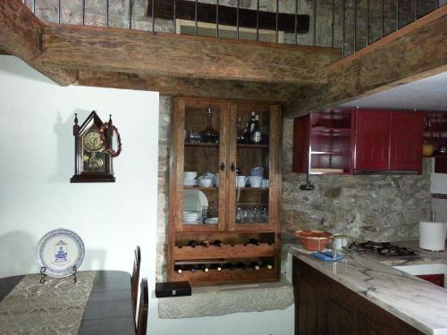 a kitchen with a table and a cabinet with wine bottles at Charming House Óbidos in Óbidos