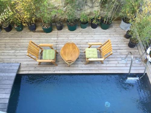 deux chaises et une table à côté d'une piscine dans l'établissement Maison au pied du Luberon, à La Motte-dʼAigues
