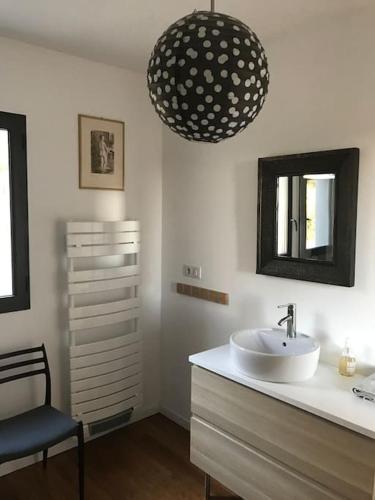La salle de bains est pourvue d'un lavabo, d'une chaise et d'un miroir. dans l'établissement Maison au pied du Luberon, à La Motte-dʼAigues