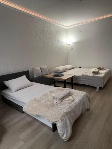 a room with two beds and a table in it at Apartman Silver Bg in Kneževac