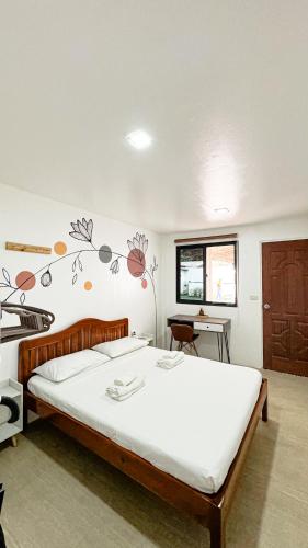 a bedroom with a large bed and a desk at Kasamigos Guesthouse with Fast Internet in Puerto Princesa City