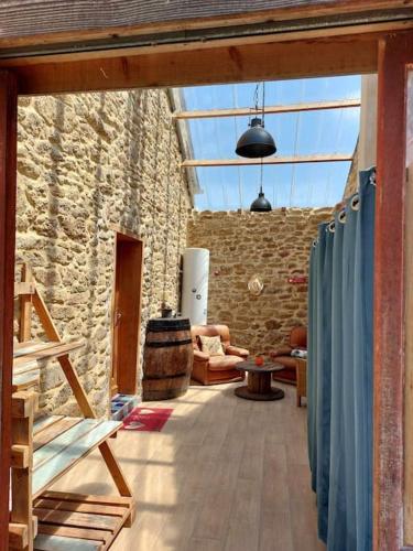 une chambre avec un mur en pierre et une chambre avec des rideaux bleus dans l'établissement Maison La Roche Quihanet, à Landéhen