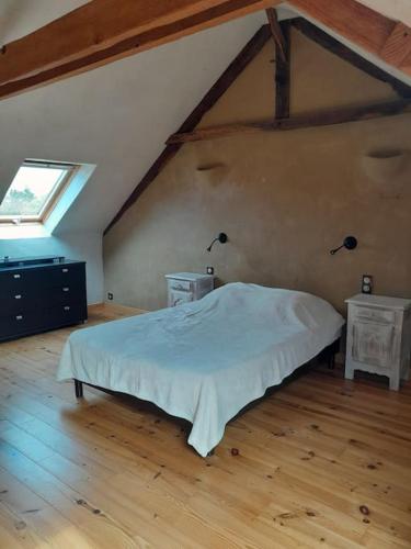 une chambre avec un grand lit et deux tables de nuit dans l'établissement Maison La Roche Quihanet, à Landéhen
