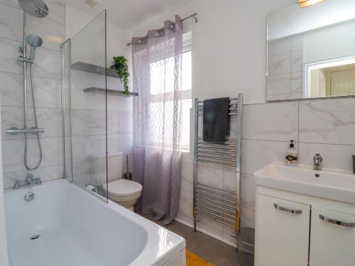 a bathroom with a tub and a toilet and a sink at 49 Waddington Road in Clitheroe