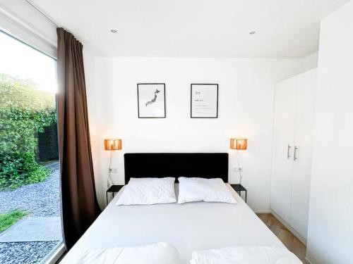 sypialnia z białym łóżkiem i dużym oknem w obiekcie Ukiyo I Ontspannen in Modern Huis met Tuin op de Veluwe w mieście Ermelo