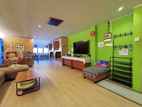 a room with green walls and a living room at AV HomeStay - Kuching MJC in Kuching