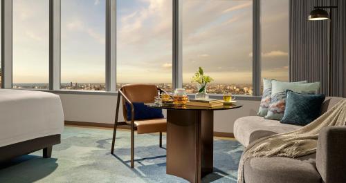 a hotel room with a bed and a table with a view at Pan Pacific Jakarta in Jakarta