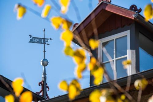 a street sign on top of a house with a cross at Niedermairhof in Brunico