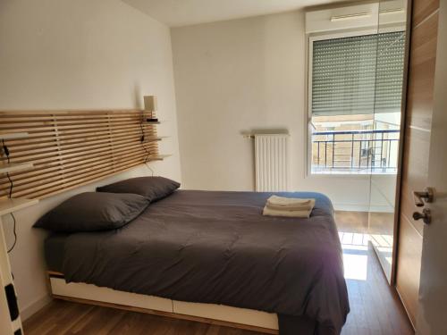 une chambre avec un grand lit et une fenêtre dans l'établissement 2 Pièces calme proche Paris, à Suresnes